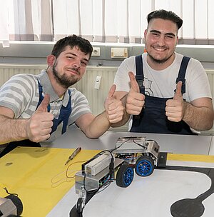 Auf dem Bild freuen sich zwei Lehrlinge über den gelungenen Bau eines Roboters. Foto: Andreas Weise / factum-fotojournalismus.de